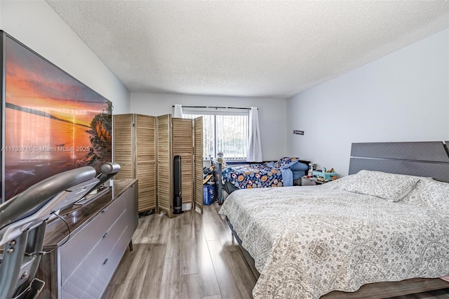 bedroom featuring wood-type flooring and a textured ceiling