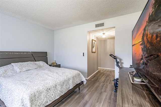 bedroom with hardwood / wood-style flooring and a textured ceiling