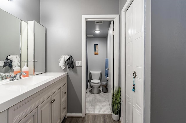 bathroom featuring vanity, toilet, walk in shower, and wood-type flooring