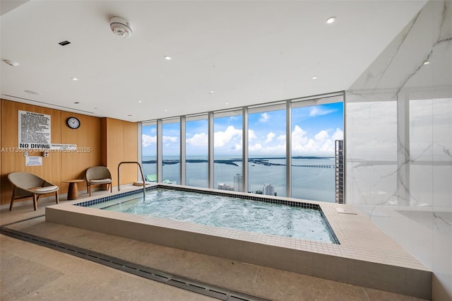 view of pool featuring a water view and an indoor hot tub