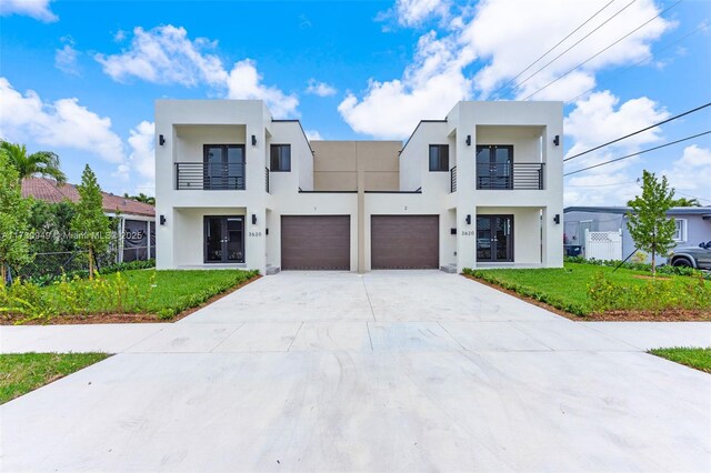 view of front of home featuring a garage, a front lawn, and a balcony