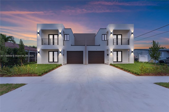 contemporary home with a lawn, french doors, and a balcony