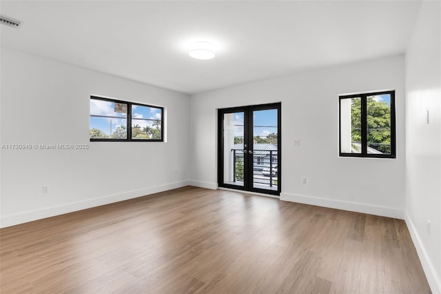 spare room with french doors and hardwood / wood-style flooring