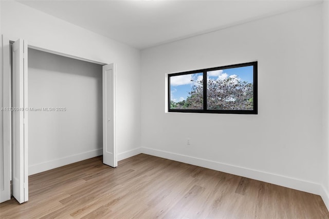 unfurnished bedroom featuring a closet and light hardwood / wood-style flooring