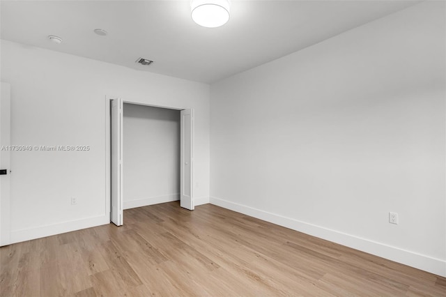 unfurnished bedroom featuring light wood-type flooring and a closet