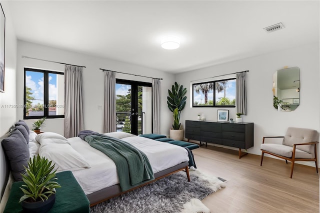 bedroom with access to exterior, french doors, and light wood-type flooring