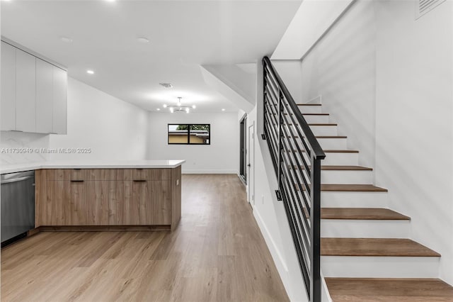 stairway featuring a notable chandelier and hardwood / wood-style flooring