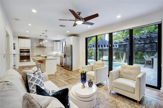 living room with light parquet flooring, ceiling fan, and french doors