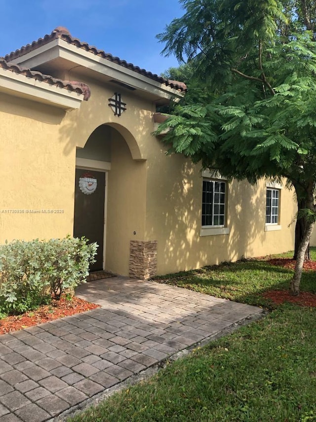 entrance to property with a patio area and a yard