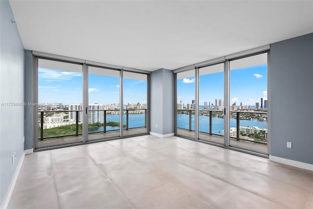 spare room with a water view and floor to ceiling windows