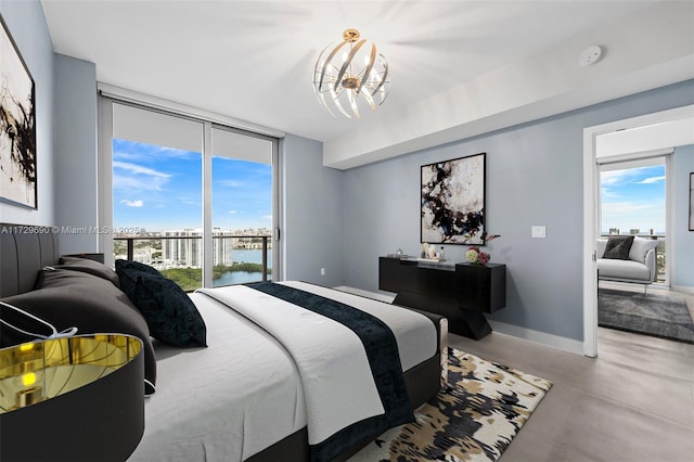 bedroom with a water view, an inviting chandelier, access to outside, and floor to ceiling windows