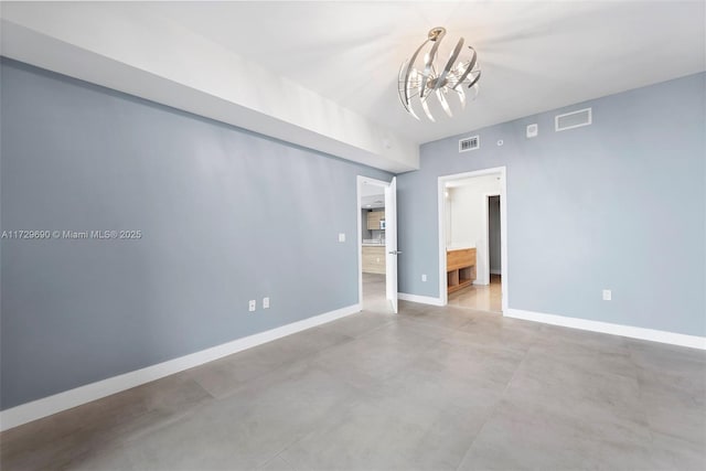 spare room featuring a notable chandelier