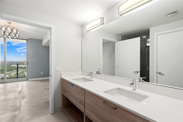 bathroom with a wall of windows, vanity, a notable chandelier, and concrete flooring