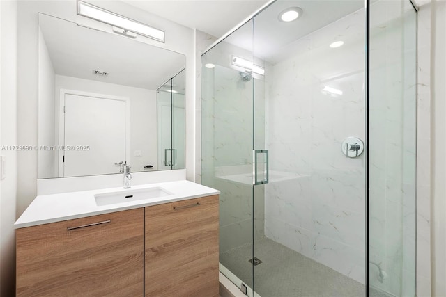 bathroom with a shower with door and vanity