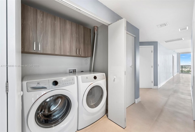 laundry room featuring washing machine and clothes dryer and cabinets