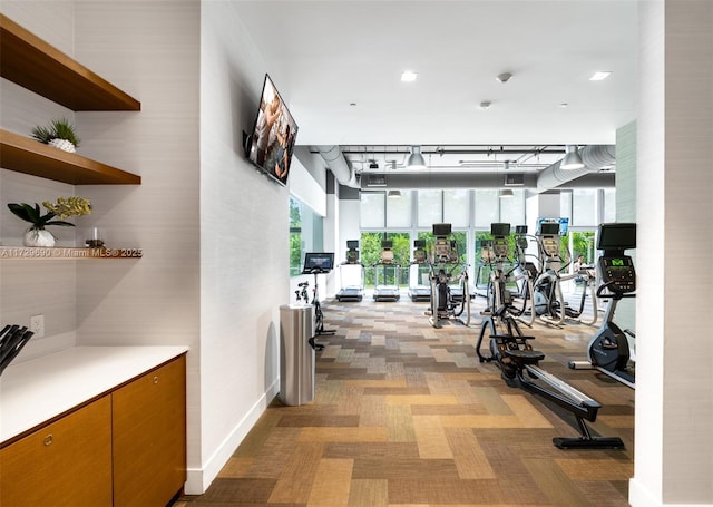 workout area with a wall of windows and light carpet