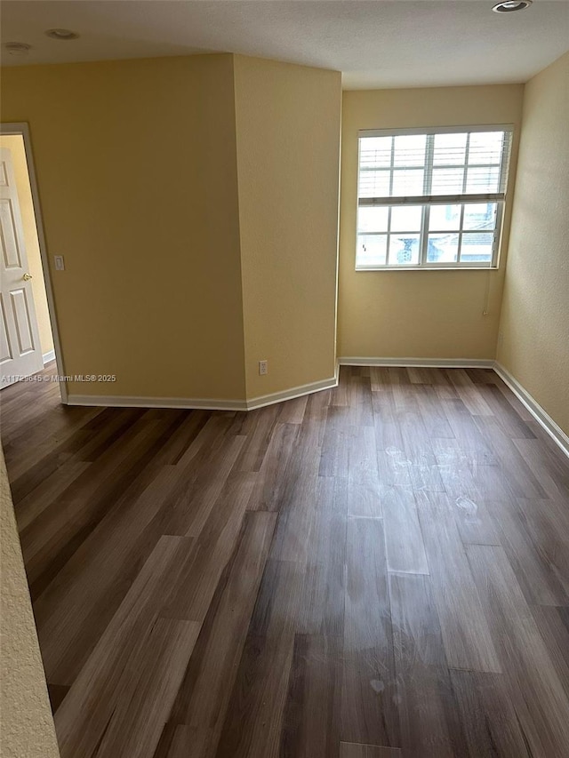 spare room with dark hardwood / wood-style floors