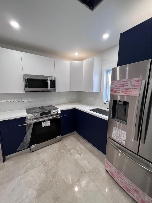 kitchen with sink, white cabinetry, appliances with stainless steel finishes, and blue cabinets