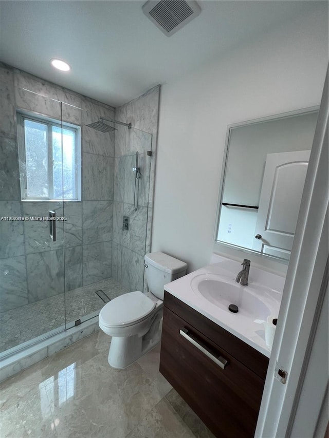 bathroom with a shower with shower door, toilet, and vanity