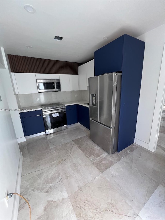 kitchen featuring backsplash, white cabinets, blue cabinetry, and stainless steel appliances