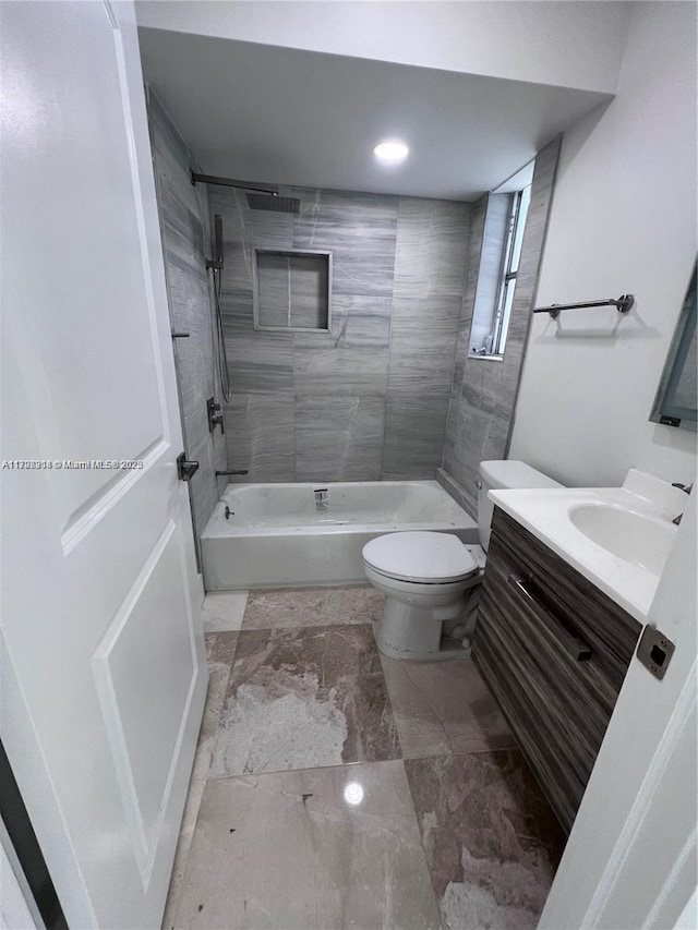 full bathroom featuring vanity, toilet, and tiled shower / bath combo