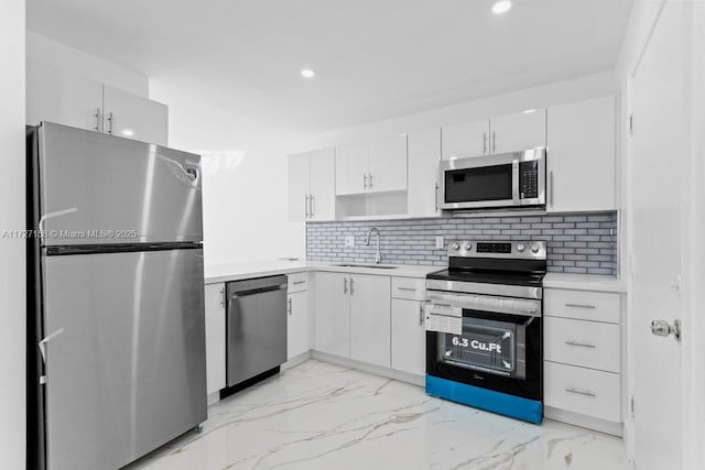 kitchen featuring sink, white cabinets, decorative backsplash, and appliances with stainless steel finishes