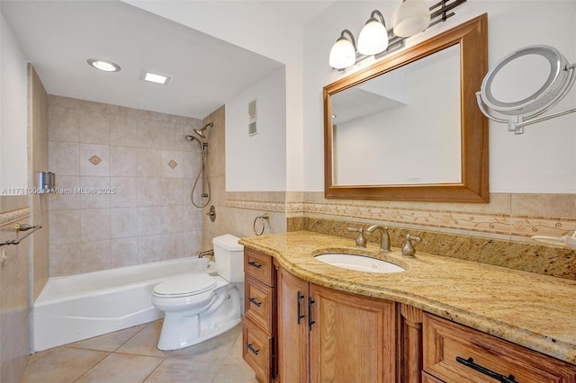 full bathroom featuring tiled shower / bath, tile patterned floors, vanity, and toilet