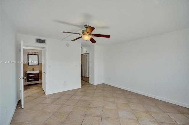 unfurnished room featuring sink, ceiling fan, and light tile patterned floors