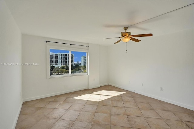 tiled spare room featuring ceiling fan