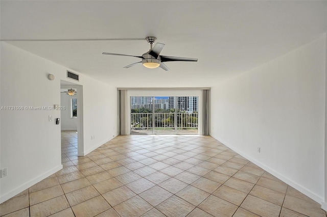 tiled empty room featuring ceiling fan