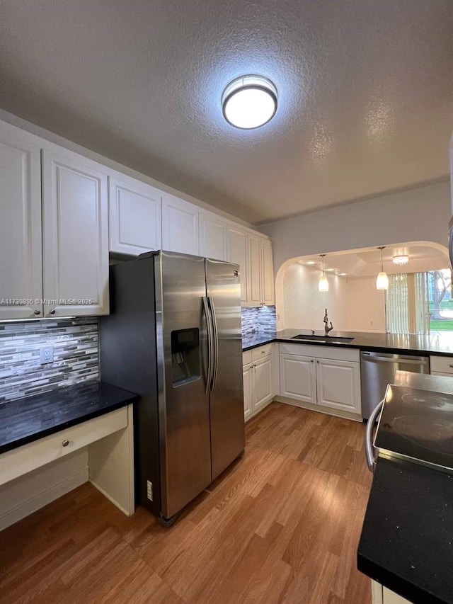 kitchen featuring decorative backsplash, sink, white cabinets, and appliances with stainless steel finishes