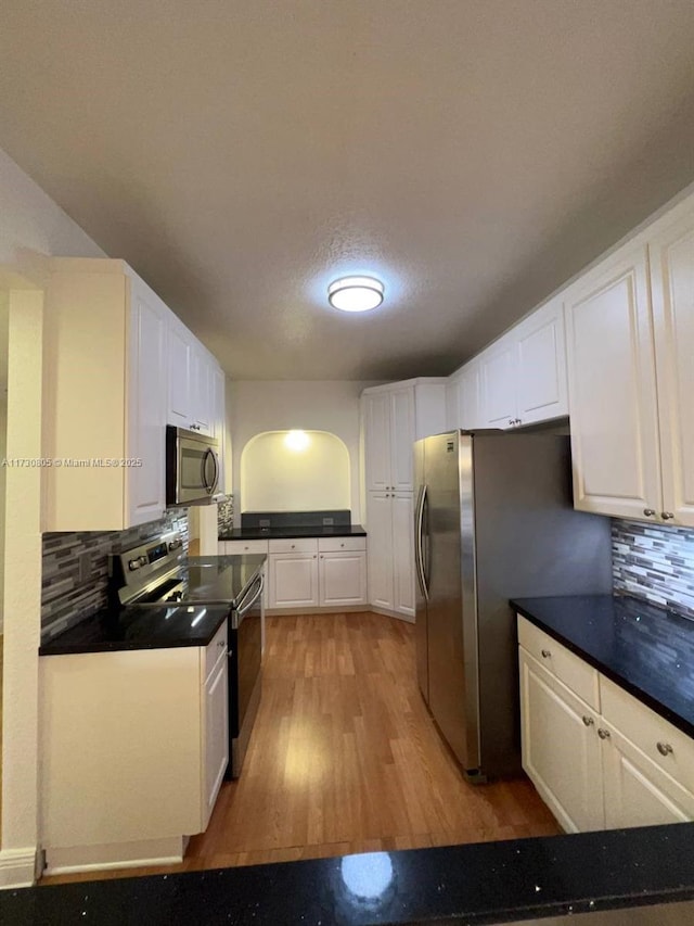 kitchen featuring white cabinets, backsplash, and appliances with stainless steel finishes