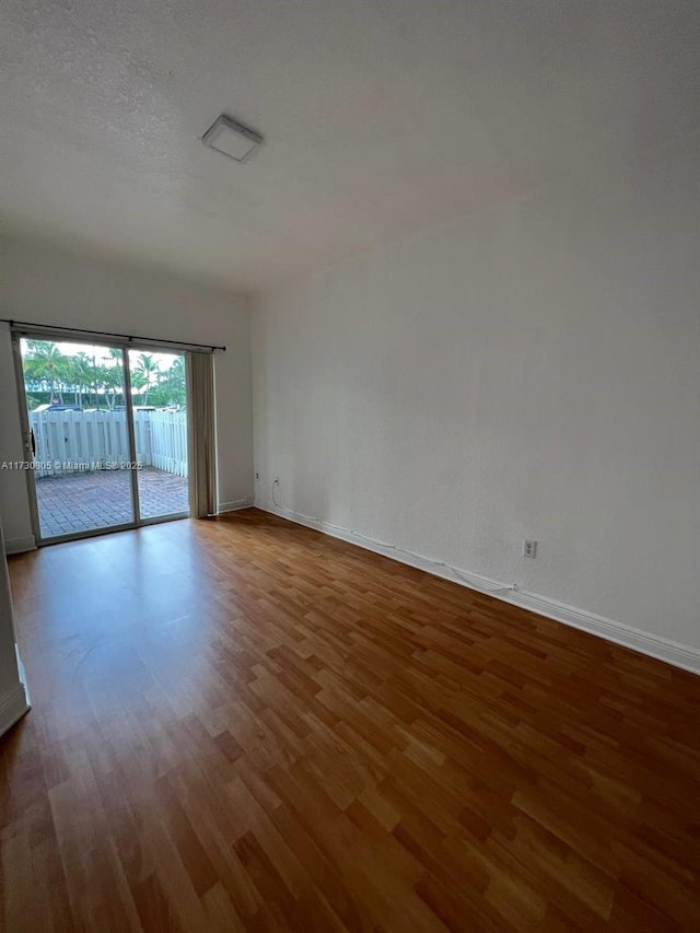 empty room with hardwood / wood-style flooring and a textured ceiling