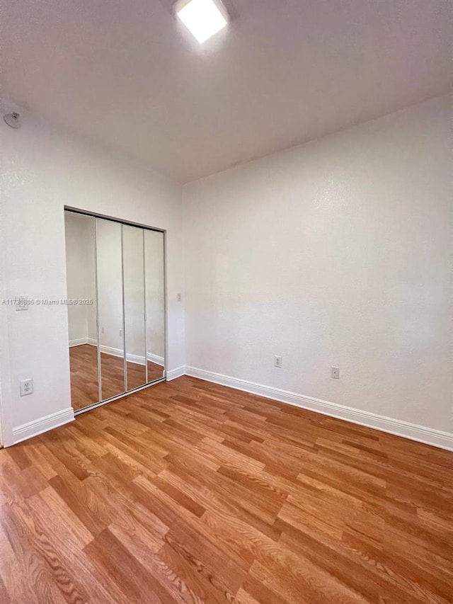 unfurnished bedroom with light hardwood / wood-style flooring and a closet