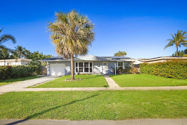 ranch-style home with a garage, a front lawn, and solar panels