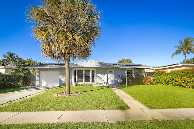 single story home with a garage, a front lawn, and solar panels