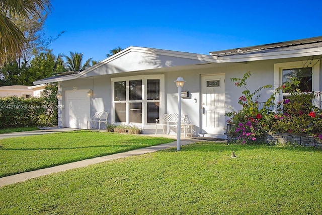 back of property with a garage and a lawn