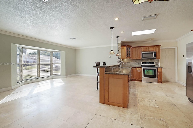 kitchen with a kitchen bar, sink, appliances with stainless steel finishes, and ornamental molding