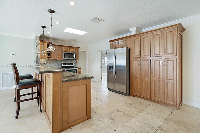 kitchen with pendant lighting, stainless steel appliances, dark stone counters, kitchen peninsula, and ornamental molding