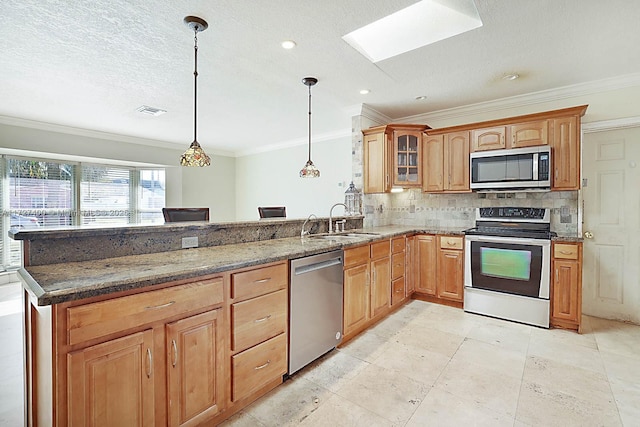 kitchen featuring decorative light fixtures, sink, dark stone countertops, and stainless steel appliances