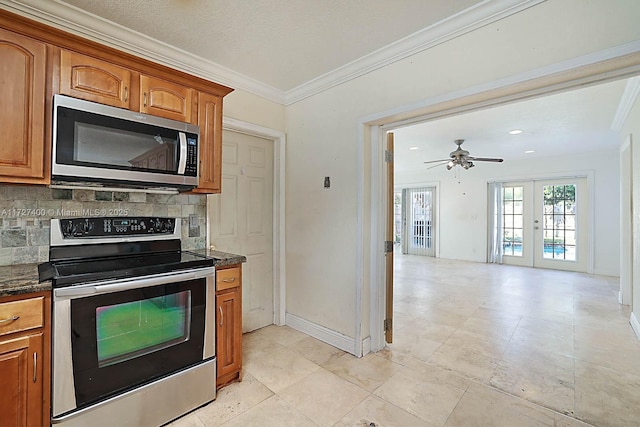 kitchen featuring crown molding, tasteful backsplash, dark stone counters, french doors, and stainless steel appliances