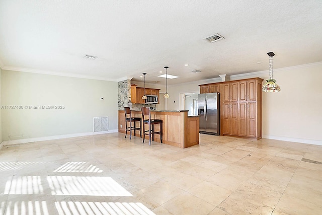 kitchen with crown molding, hanging light fixtures, a kitchen island, a breakfast bar, and stainless steel appliances