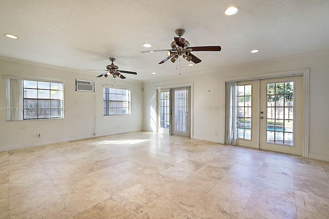 unfurnished room with an AC wall unit, plenty of natural light, crown molding, and french doors