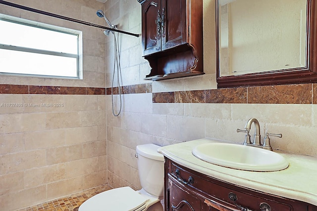 bathroom featuring tiled shower, toilet, and vanity