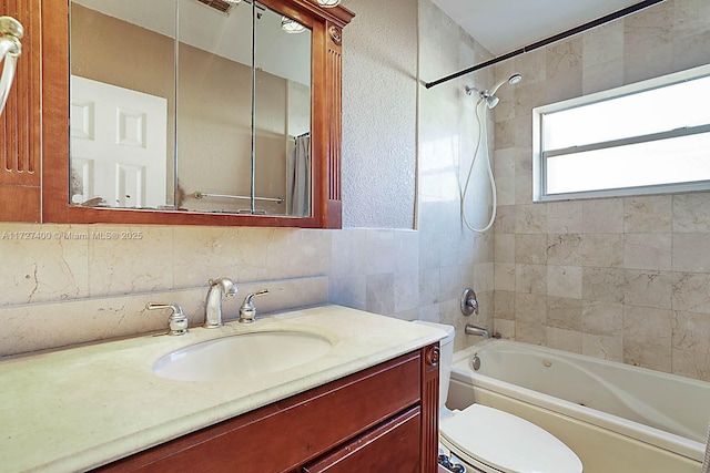 full bathroom with decorative backsplash, tiled shower / bath combo, vanity, and toilet