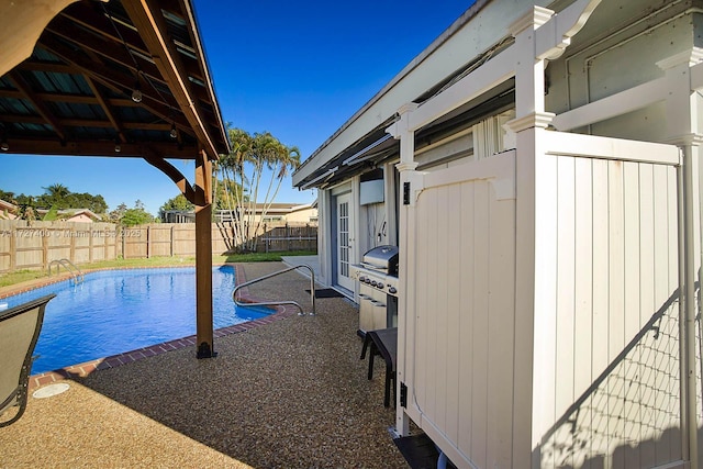 view of swimming pool featuring a patio and grilling area