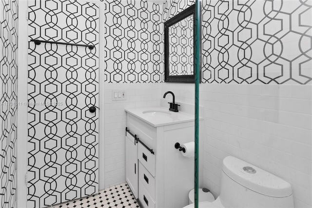 bathroom featuring tile walls, toilet, and vanity