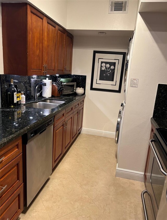 kitchen with dishwasher, stove, sink, dark stone countertops, and backsplash