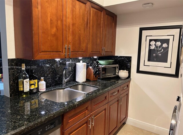 kitchen featuring dishwasher, dark stone counters, decorative backsplash, sink, and light tile patterned floors