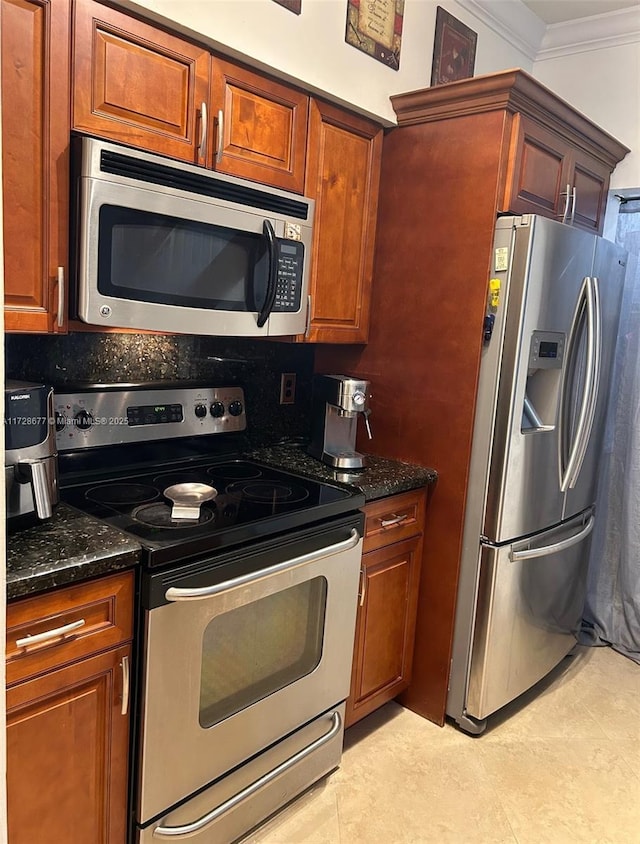 kitchen with dark stone counters, ornamental molding, appliances with stainless steel finishes, and decorative backsplash